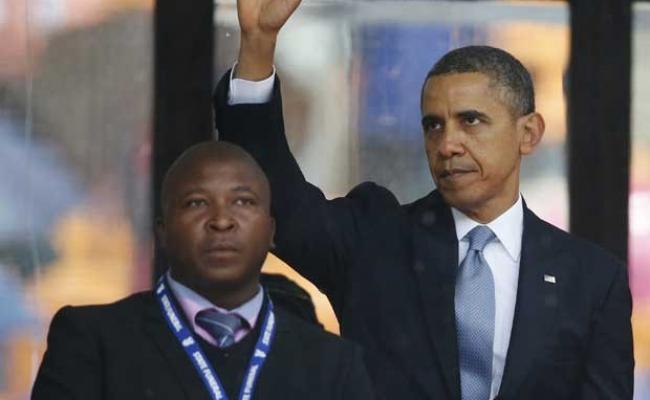 Thamsanqa Jantjie (ao lado de Obama) disse a jornal local que estava ouvindo vozes enquanto estava no palco de homenagem a Mandela