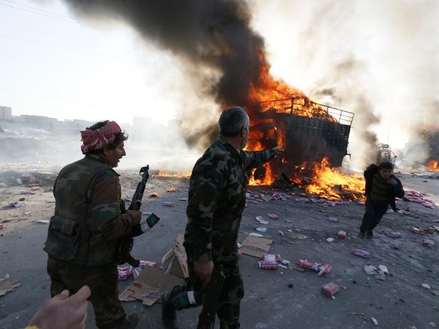 do rebelde Exército Livre Sírio reagem a um veículo queimado em um ataque aéreo do governo em Aleppo Foto: Reuters