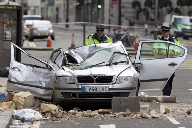 Carro ficou destruído após ser atingido pela parte do prédio derrubada pela ventania em Londres. Uma mulher morreu (Foto: Justin Tallis/AFP)